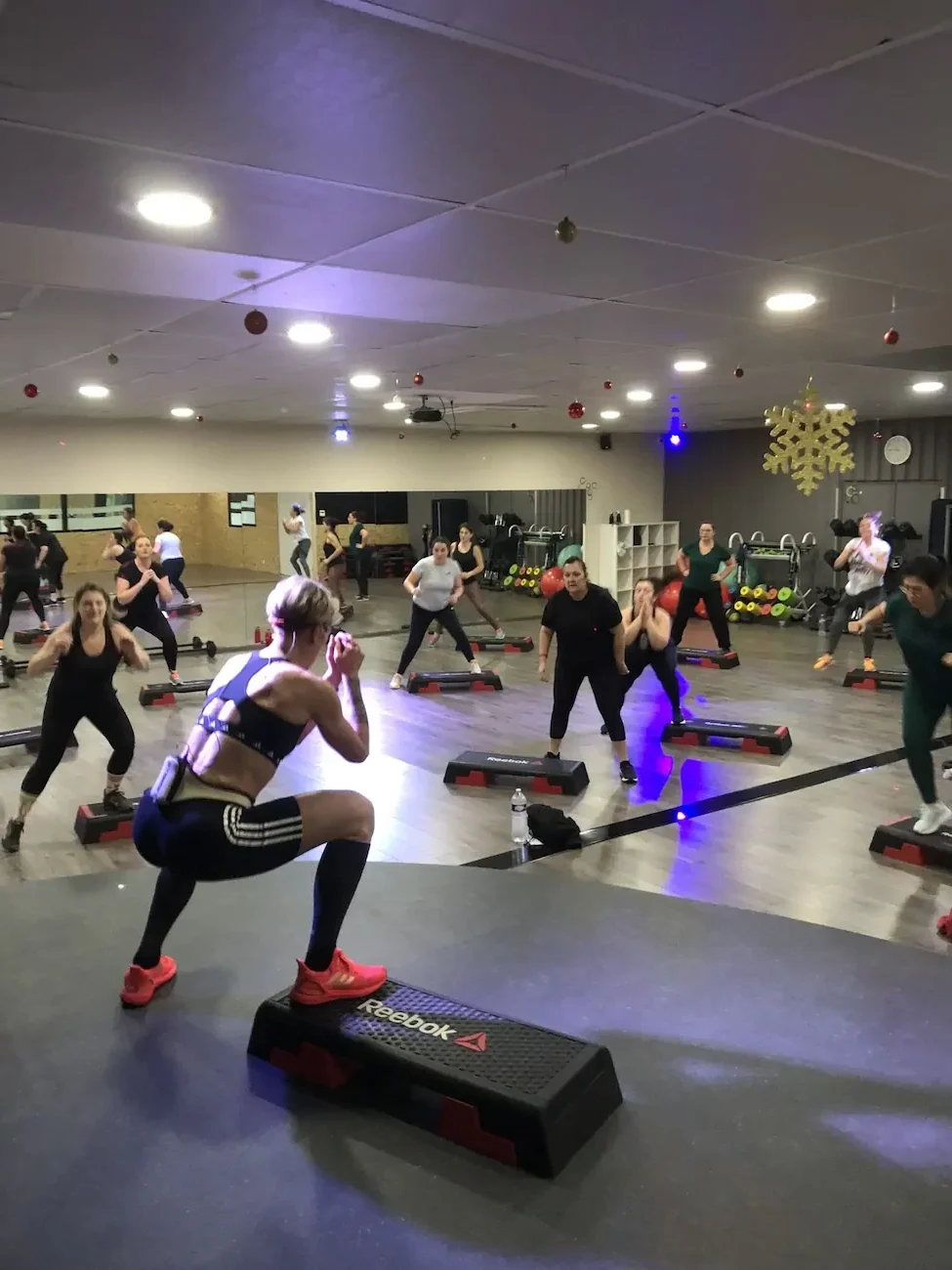 Cours de fitness collectif en salle décorée.