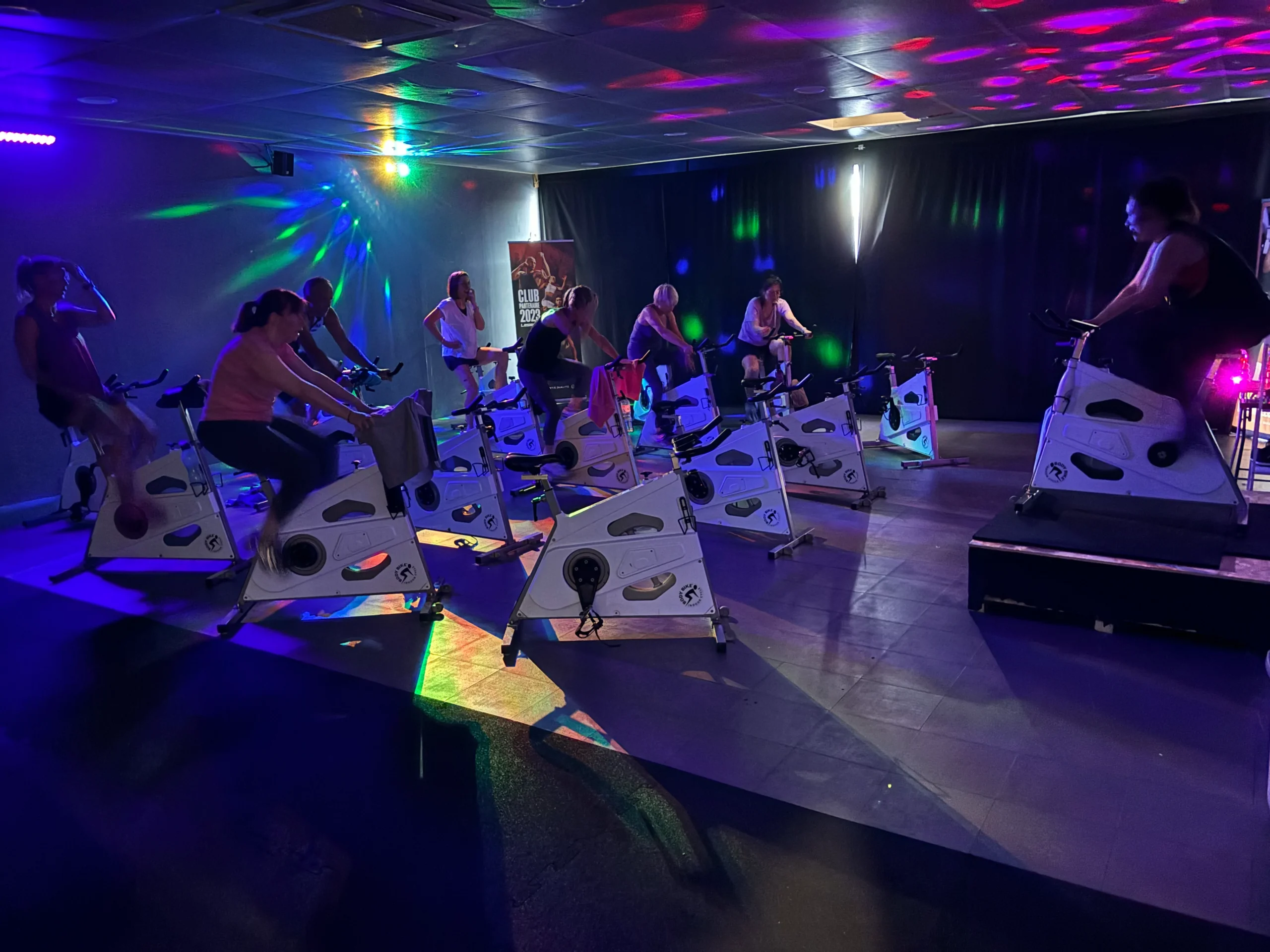 Cours de vélo en salle avec éclairage disco