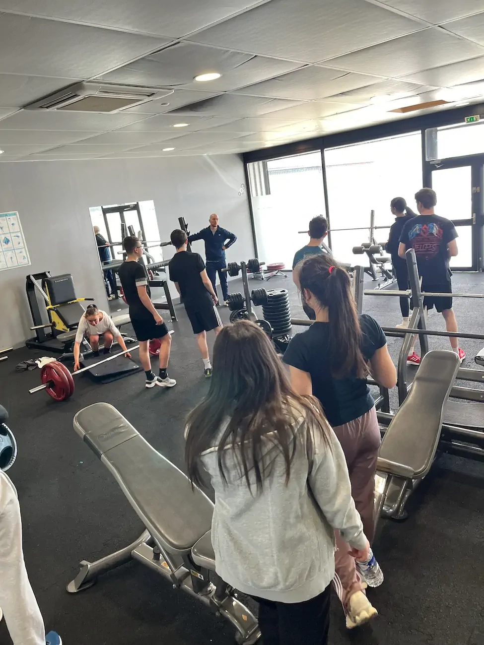 Salle de gym avec personnes s'entraînant.